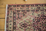 Corner detail of an antique Kerman rug showing the fully secured side and short fringe.
