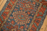 Vintage Karaja rug detail: Denim blue field with madder red geometric motifs and serrated border.