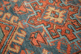 Vintage Karaja rug's geometric hook and latch pattern in madder red, denim blue, beige.