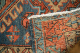 Folded Vintage Karaja rug reveals geometric denim blue pile and madder red foundation.