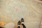 Distressed vintage Oushak rug with light pink T-stain on muted beige and ivory field.