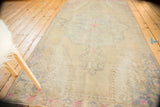 Distressed vintage Oushak rug with faded central medallion and soft beige tones.