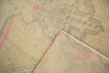 Distressed vintage Oushak rug pile texture with faded beige, gray, pink, and tightly woven back.