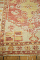 Distressed Oushak rug detail: dusty cherry red, saffron stepped patterns, floral border.