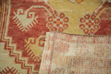 Hand-knotted foundation visible below distressed red and saffron pile of vintage Oushak rug.