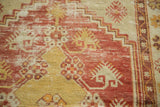 Distressed Oushak rug pile: stepped spandrel and diminutive floral motifs in red and saffron.