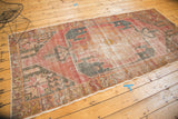 Distressed Turkish Oushak runner corner showcasing floral border, cherry red hues, and wear.