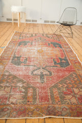 Distressed Oushak runner's floral bud border in cherry red and dark gold.