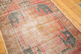 Distressed Oushak runner texture, showing cherry red, burnt orange, and charcoal geometric motifs.