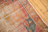 Distressed Oushak runner pile with serrated geometric motifs in burnt orange, red, and charcoal.