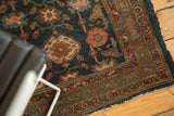 Persian Fine Lilihan runner corner with indigo field, faded red arabesque motifs, and hard tattered edge.