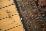 Tattered side edge of antique Lilihan runner, showcasing detailed indigo and raspberry arabesque border.