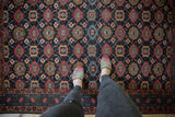 Floor view of a vintage Malayer rug's vivid geometric pattern in indigo and raspberry red.