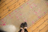 Vibrant pink distressed patterns on the textured pile of a vintage Oushak runner.