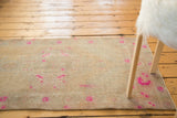 Vintage distressed Oushak runner with bright pink floral motifs on a pale beige field.