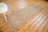 Distressed Turkish Oushak runner showcasing bright pink floral motifs with decorative even wear.