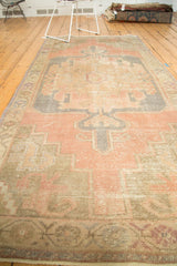 Distressed Oushak runner's geometric border, showing faded dusty rose, beige, and blue.