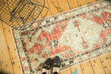 Distressed vintage Oushak runner with serrated hexagonal design in faded cherry red and powder blue.