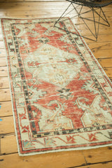 Distressed Oushak rug with sharp serrated red and ivory medallion design.