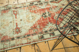 Faded red and ivory geometric patterns on the distressed Oushak rug runner edge.