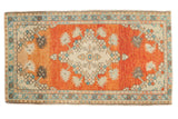 Vintage distressed Oushak rug with a vibrant orange field, ivory medallion, and dynamic florals.
