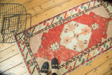 Distressed cherry red field with geometric lattice corner spandrel of the Oushak rug.