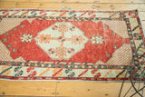 Distressed cherry red field with ivory lattice corner spandrel on a vintage Oushak rug.