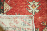 Distressed Oushak rug's cherry red pile and visible hand-knotted foundation.