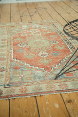 Distressed Oushak rug with stepped border detail, faded red and sea foam green tones.