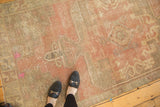 Distressed vintage Oushak rug texture with faded medallion, dusty rose, and hot pink hues.