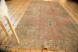 Distressed Oushak rug corner featuring starburst spandrel, serpent border, and fluorescent hot pink.