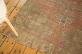 Decorative distressed Oushak rug detail showing blush, oxidized silver, and fluorescent hot pink.