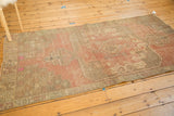 Distressed texture, serpent border, and blush tones of a vintage Oushak rug.