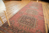 Distressed vintage Oushak runner showing soft raspberry, pale blue, and charcoal rectilinear gul motifs.
