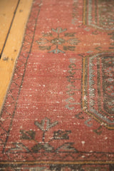 Distressed Oushak rug detail with textured raspberry red field and pale blue motifs.