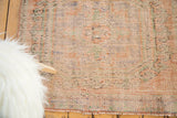 Distressed texture of a vintage Oushak rug with worn pile, pale terra cotta, sea foam, and slate tones.