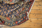 Antique Caucasian rug: blue blossomed flower pattern on camel, intricate red borders.