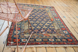 Antique Caucasian rug corner with geometric borders, blue blossom motifs, and restrung foundation.