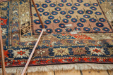 Blossomed flower motif, geometric borders, fringe, and restrung areas of antique Caucasian rug.
