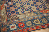 Antique Caucasian rug corner, intricate dark navy, brick red borders, and blue blossomed motif.