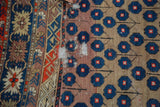 Antique Caucasian rug detail: blue blossomed pattern, geometric border, and restrung foundation.