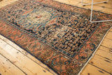 Antique Malayer rug border featuring rococo-influenced madder red motifs and indigo field.