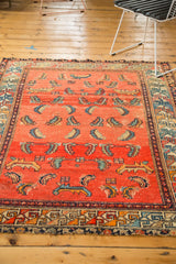 Antique Hamadan rug's intricate geometric border in navy, teal, orange, tattered.
