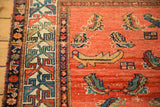 Geometric border and stylized Mahi motifs on the abrashed blush field of an antique Hamadan rug.