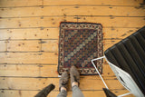 Tattered end of antique Afshar Bag Face rug showing indigo and wine red gul motifs.