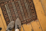 Vintage Belouch Bag Face rug displaying geometric running water motif with heavy tatter on end.