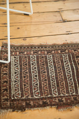 Geometric brown, camel, ivory water motif on vintage Belouch rug's tattered end.