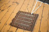 Vintage Belouch bag face rug: geometric running water motif in ivory, camel, dark brown. Tattered edges.
