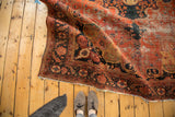 Intricate navy floral border and trefoil corner spandrels on an antique Farahan Sarouk carpet.