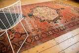 Traditional Persian Farahan Sarouk rug corner with blush, navy floral vinery and tattered edge.